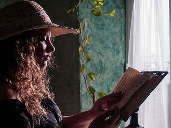 Woman reading book on table at home