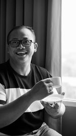 Portrait of smiling man sitting by window