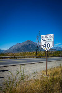 Road sign against blue sky