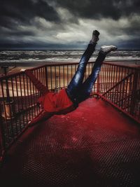 Boy on beach against sky