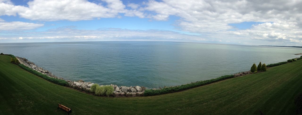 sea, sky, tranquil scene, water, horizon over water, tranquility, scenics, beauty in nature, grass, cloud - sky, nature, beach, cloud, landscape, idyllic, coastline, green color, cloudy, shore, high angle view