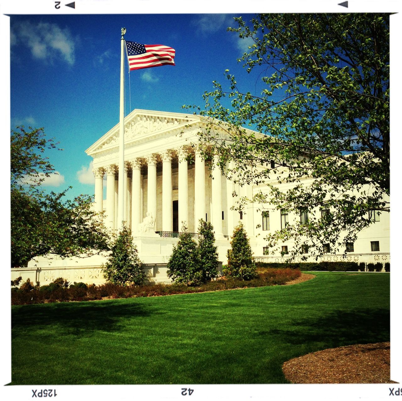 building exterior, architecture, built structure, transfer print, grass, tree, lawn, flag, sky, auto post production filter, patriotism, green color, day, american flag, sunlight, low angle view, national flag, clear sky, identity, outdoors