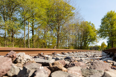 Surface level of railroad track amidst rocks against sky