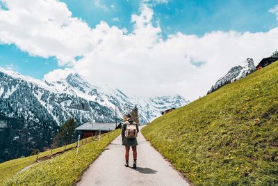 Rear view of women walking on mountain against sky