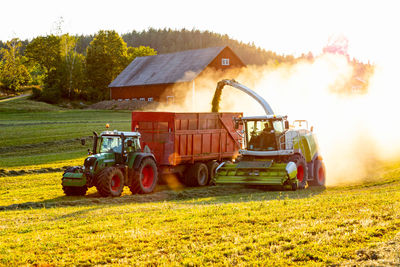 Forage harvester and tractor on field