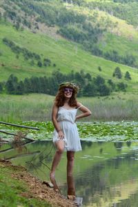 Full length of a smiling young woman standing on water