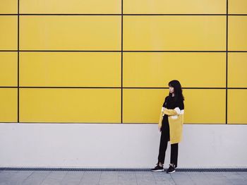 Full length of man standing on yellow umbrella