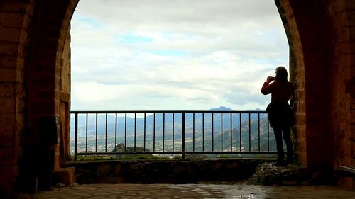 People standing against cloudy sky