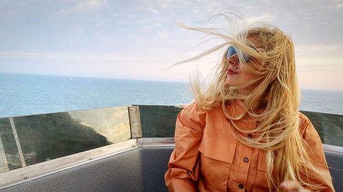Woman wearing hat against sea against sky