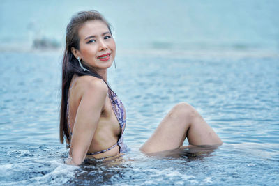 Portrait of smiling young woman in bikini