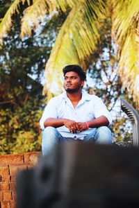 Young man sitting on bench