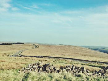 Scenic view of landscape by sea against sky