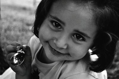 Close-up portrait of cute girl holding spoon
