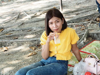 Portrait of young woman sitting outdoors