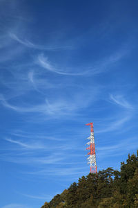 Low angle view of communications tower against blue sky