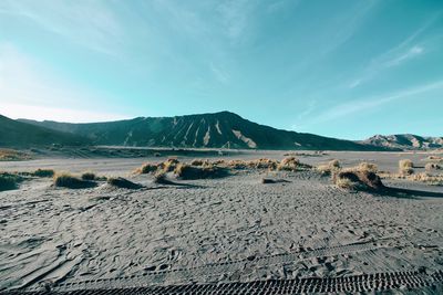 Scenic view of arid landscape against sky near mount bromo