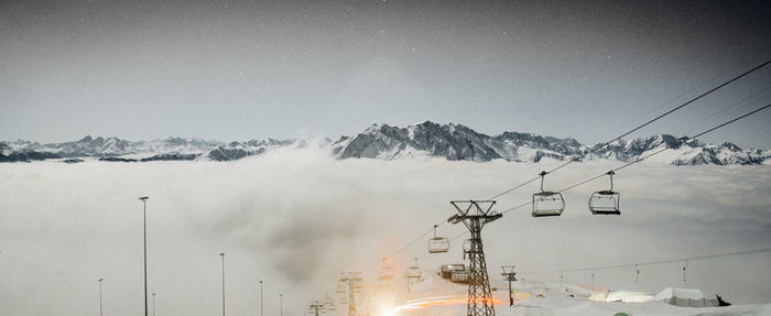 View of ski lift and snow covered mountains