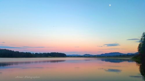 Scenic view of lake against sky at sunset