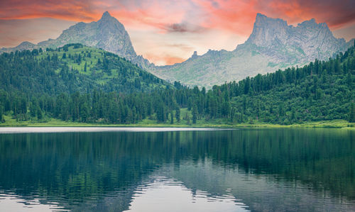 Scenic view of lake and mountains against sky during sunset