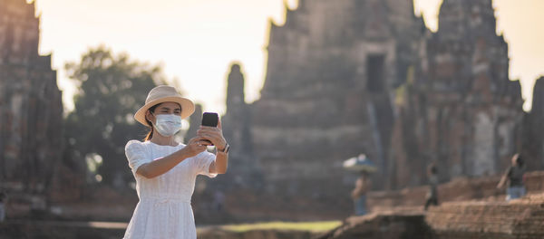 Young woman photographing through smart phone