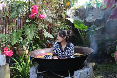 Portrait of woman standing by plants