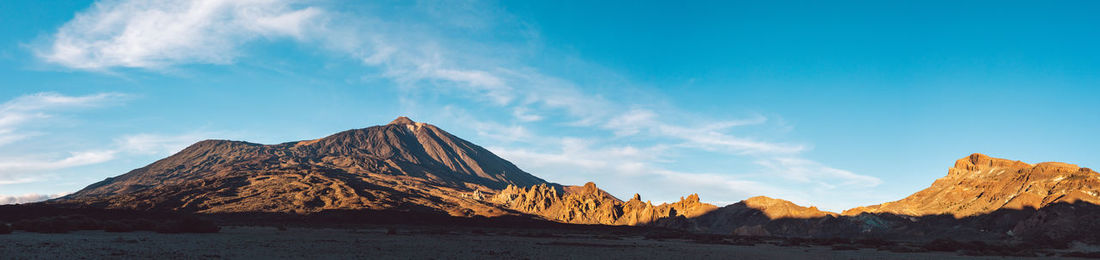 Panoramic view of snowcapped mountains against blue sky