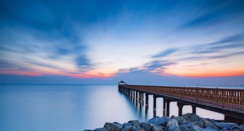 Bridge over sea against sky during sunset