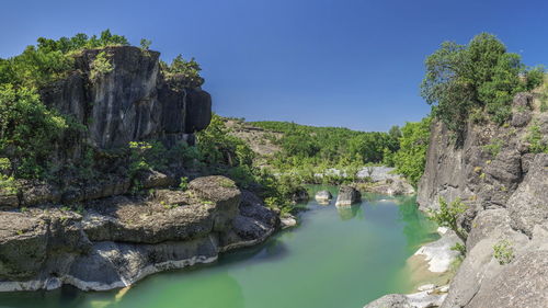 Scenic view of river against blue sky