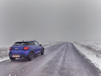 Car on road against clear sky during winter