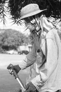 Side view of man holding lawn mover