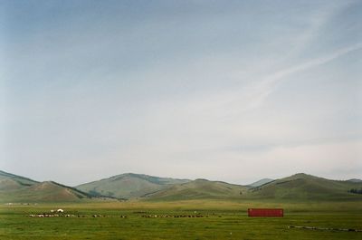 Scenic view of field and mountains against sky