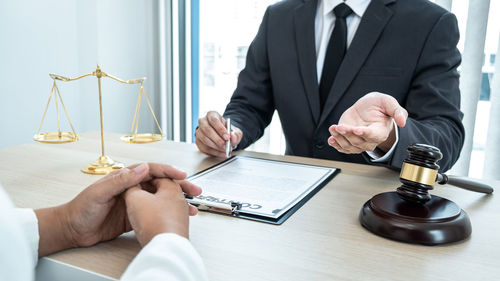 Midsection of lawyer working at desk in courtroom
