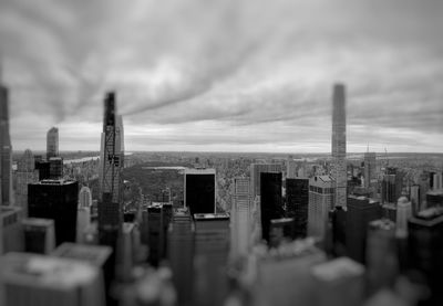 Panoramic view of buildings in city against cloudy sky