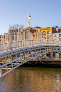 Bridge over river in city against clear sky