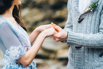 Midsection of couple holding hands