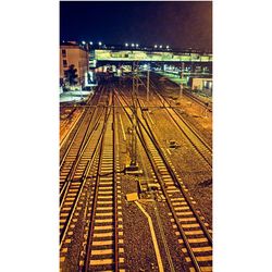 Railroad tracks in city against sky at night