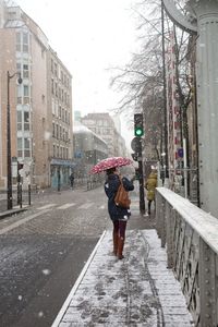 Rear view of woman walking on street in city