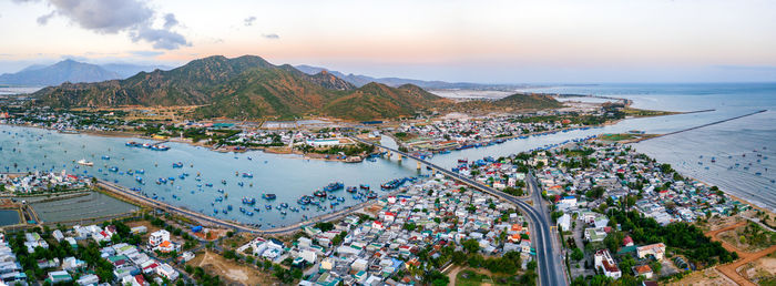 High angle view of townscape by sea against sky