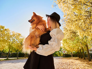 Pretty blond girl play with pomeranian dog