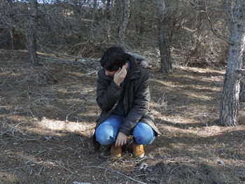 Full length of man crouching on field