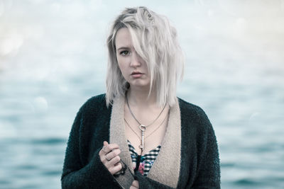 Portrait of beautiful young woman wearing chain with key pendant at beach