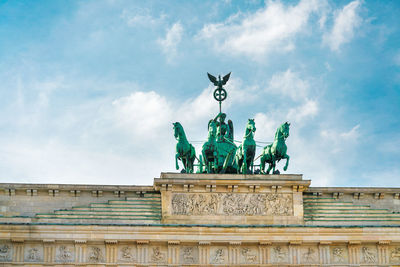 Low angle view of sculpture on building against sky