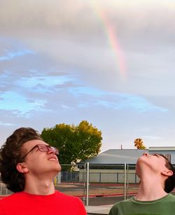 Beautiful young woman with rainbow against sky