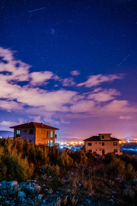 Houses and buildings against sky at night