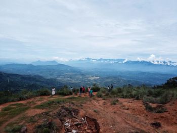 Group of people on mountain against sky