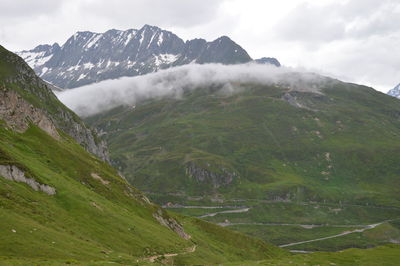 Scenic view of mountain range against cloudy sky