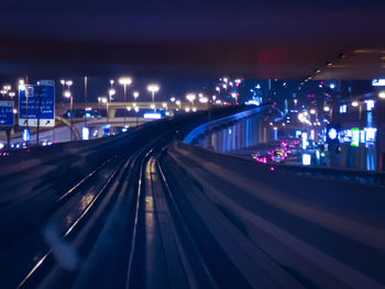 High angle view of illuminated street amidst buildings at night