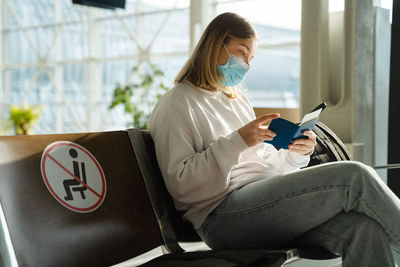 Young woman using laptop while sitting on chair at home