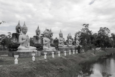 Panoramic view of statues on building by trees against sky