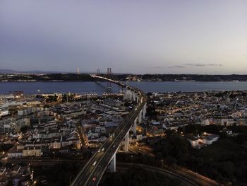 High angle view of illuminated city by buildings against sky